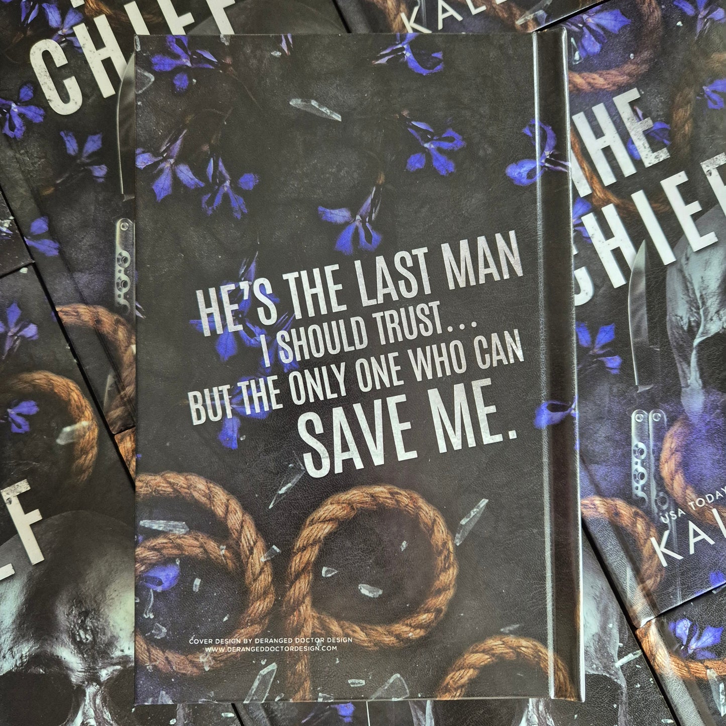 Stack of books with a dark cover featuring text and a rope illustration.