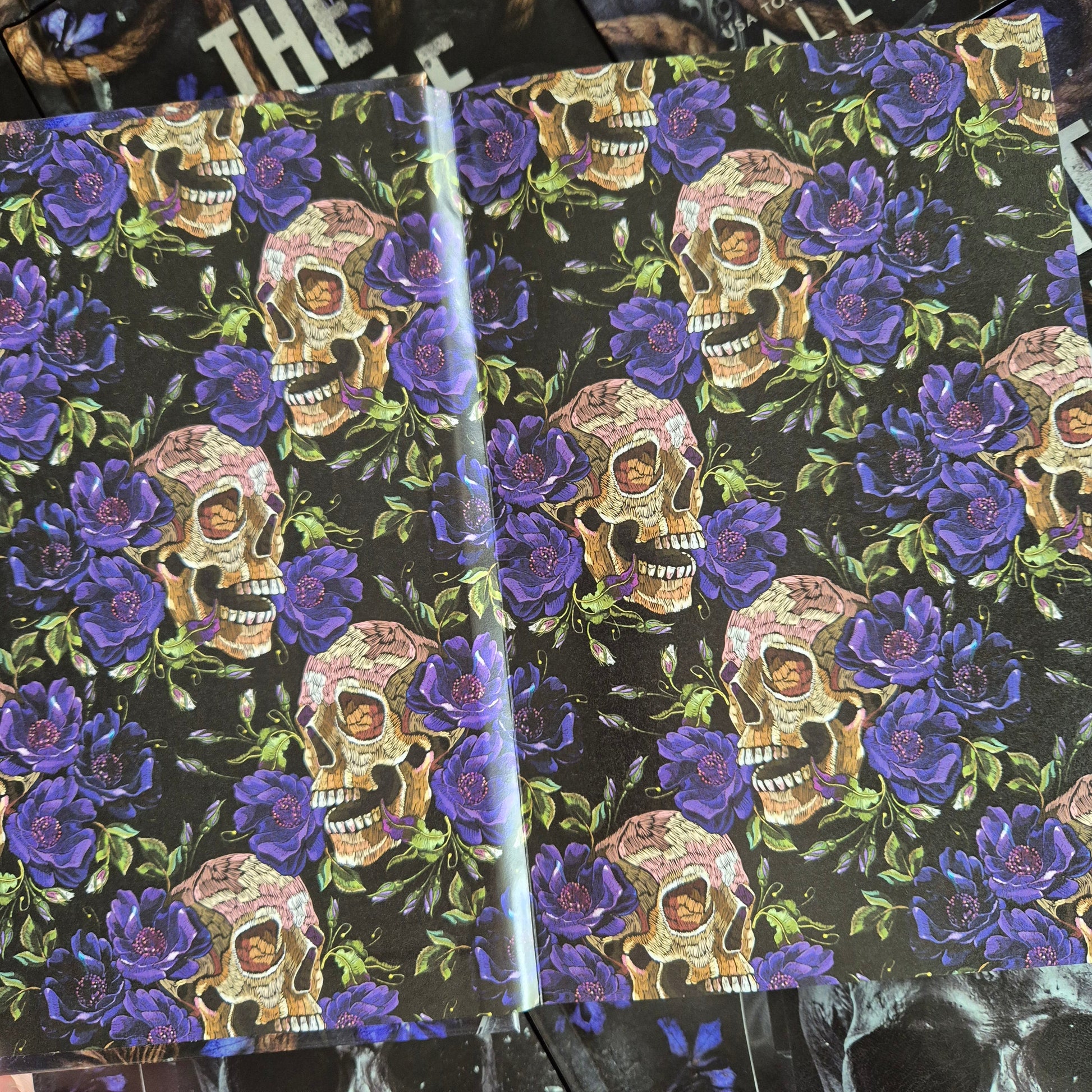 Endpaper design with skull and floral pattern on black background