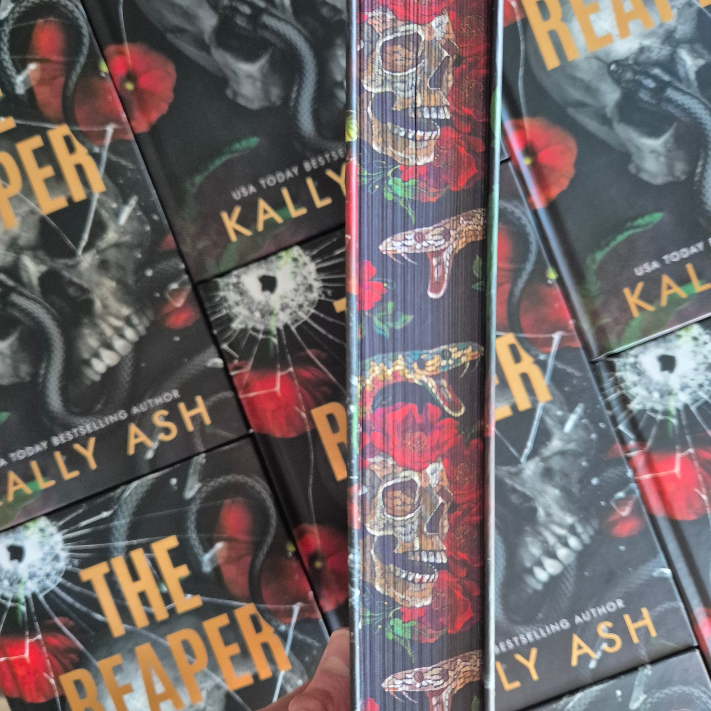 Close-up of Kally Ash book with sprayed edge design of snakes, skulls and roses.